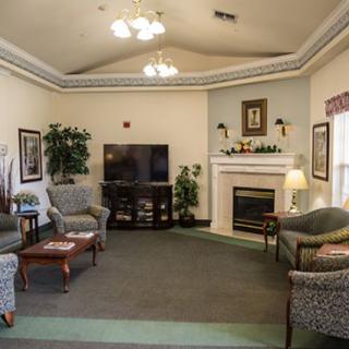 A cozy living room with a television and a fireplace, featuring comfortable seating and elegant decor.