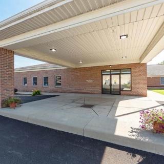 Entrance of a brick building with an awning and potted plants.