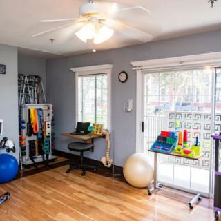 A well-equipped rehabilitation room with various physical therapy tools and exercise equipment.