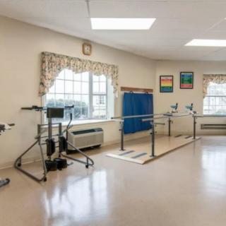 A therapy room equipped with parallel bars and other rehabilitation equipment.