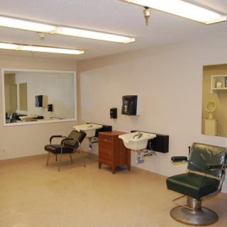An empty barber shop with chairs, mirrors, and sinks.