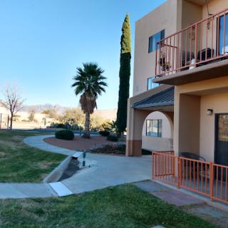 A peaceful apartment complex with landscaped pathways and palm trees.