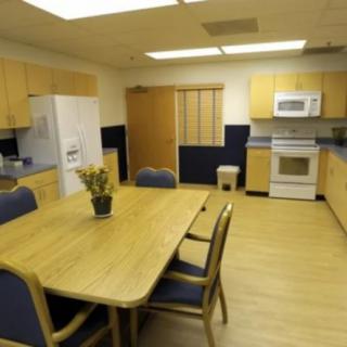 A modern kitchen with wooden cabinetry, a dining table, and appliances.