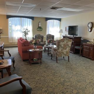 A cozy living room with a variety of seating options and a television.