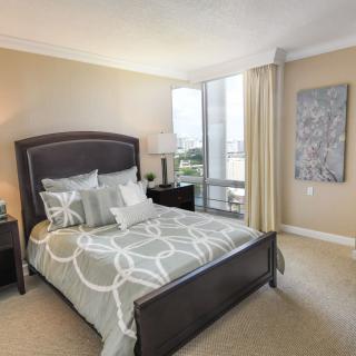 Modern bedroom with stylish decor and large window.