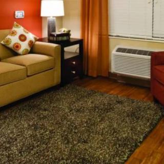 A cozy living room with a beige sofa, colorful cushions, and a shaggy rug.