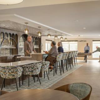 A modern cafe interior with people seated around a bar counter.