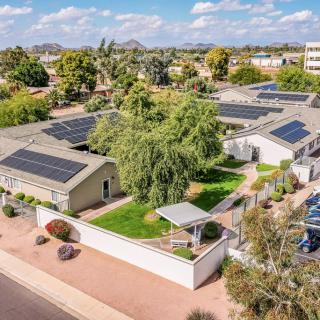 An aerial view of a residential area showcasing homes equipped with solar panels and surrounded by greenery.