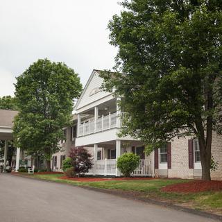 A scenic view of a building with surrounding trees and well-maintained landscaping.