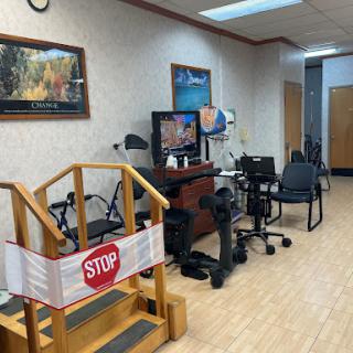 A rehabilitation center with a stop sign in front of a set of stairs, featuring chairs and medical equipment.