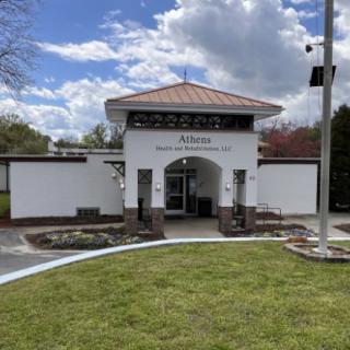 The entrance to a modern museum with a landscaped exterior under a cloudy sky.