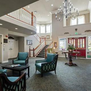 A spacious and well-lit lobby with elegant furniture and a chandelier.