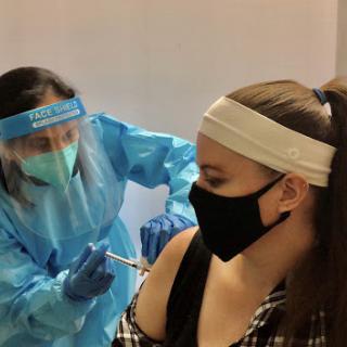 A healthcare professional administering a vaccine to a patient in a safe environment.