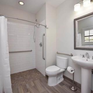 A modern bathroom with a shower, toilet, and sink.