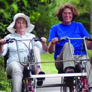 Two people enjoying a tandem bike ride outdoors.