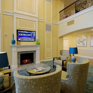 A modern living room with a fireplace, television, and cozy seating area adorned with decorative lamps.