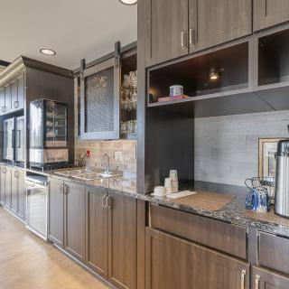 A modern kitchen interior featuring dark wooden cabinets and a sleek countertop.