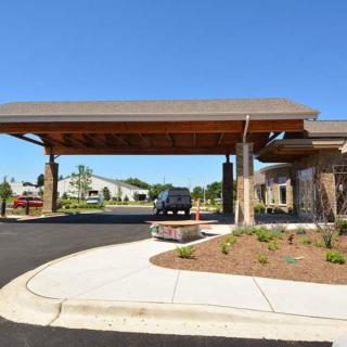 A car parked under a large canopy at the entrance of a building.