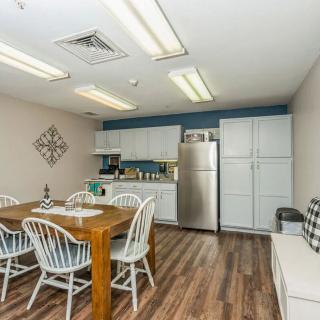 A cozy kitchen and dining area featuring a wooden table with chairs, modern appliances, and ample cabinetry.