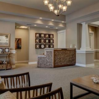 A modern living room with elegant furnishings and a chandelier.
