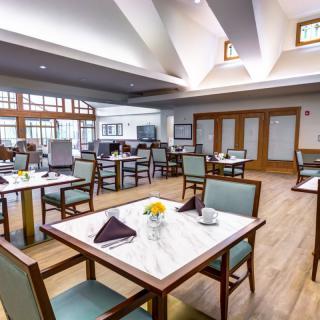 A spacious and elegantly designed dining area with neatly arranged tables and chairs.