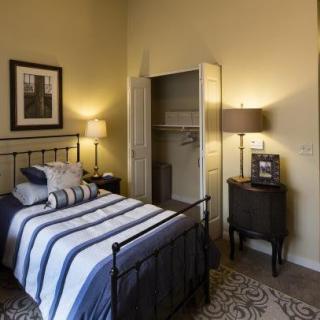 Cozy bedroom with a striped bedspread and warm lighting.