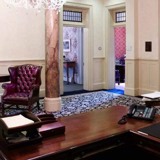 A well-furnished office space with a large wooden desk and a leather chair.