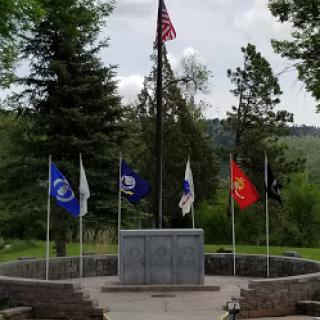 A memorial dedicated to veterans, featuring the American flag and various service flags.