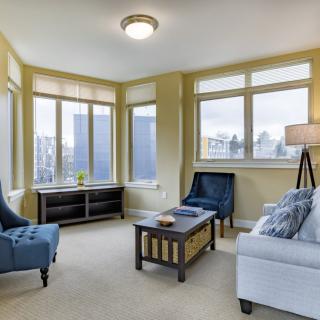 A cozy living room with comfortable seating and large windows allowing natural light to fill the space.