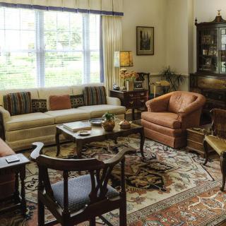 A cozy living room with vintage furniture and a decorative rug.