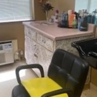 A salon interior featuring a barber chair and various beauty products on the counter.