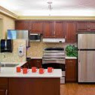 A modern kitchen with stainless steel appliances and wooden cabinets.