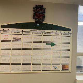 A monthly calendar displayed in an office setting for planning and scheduling activities.