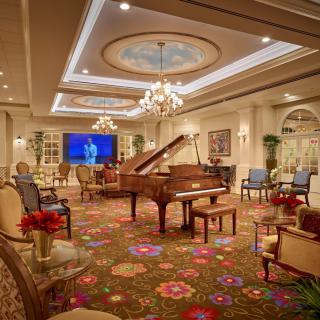 A luxurious living room with a grand piano and elegant decor.