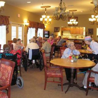 Elderly individuals socializing in a nursing home dining area.