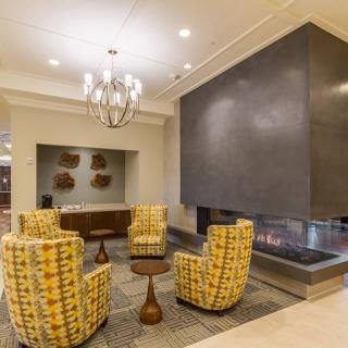 A modern lobby interior featuring a stylish fireplace and comfortable seating area.