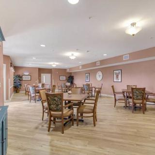 A spacious dining area with multiple tables and chairs, well-lit and tastefully decorated.