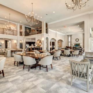 A luxurious and spacious dining area adorned with elegant chandeliers and comfortable seating.