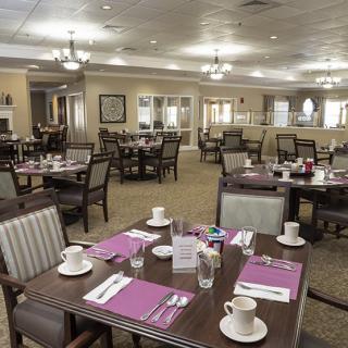 An elegant dining room with neatly arranged tables and place settings, ready for guests.