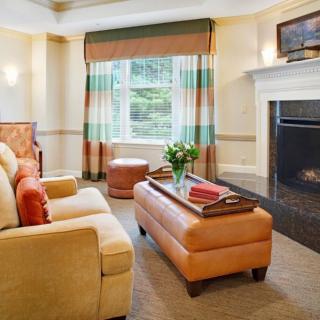 A cozy and elegantly decorated living room with a fireplace, comfortable sofa, and a well-designed coffee table.