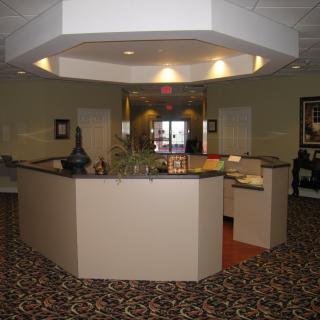 A well-lit office lobby featuring a reception desk with decorative items.