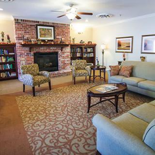 Cozy living room with a brick fireplace, comfortable seating, and elegant decor.