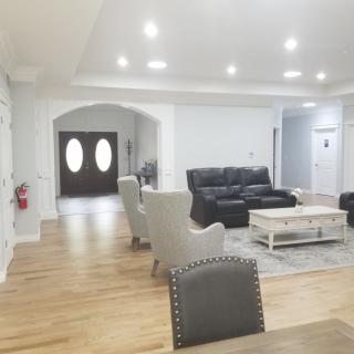 A spacious living room with modern furniture and bright lighting.