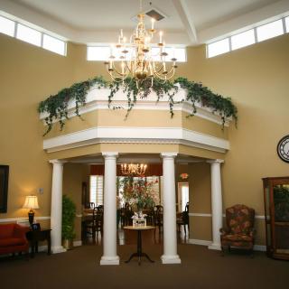 A luxurious lobby interior with a chandelier and decorative columns.