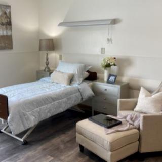 A well-decorated, cozy room featuring a hospital bed and a comfortable armchair.