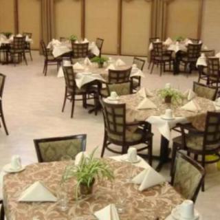 A banquet hall with neatly arranged tables and chairs, prepared for an event.