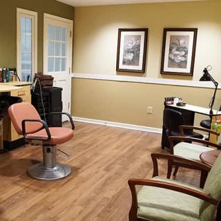 A neatly arranged office space with a chair and desk, featuring framed artwork on the wall.
