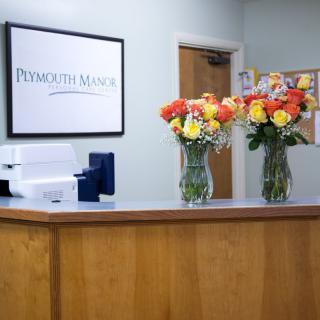 A welcoming office reception area with two vases of colorful flowers on the desk.