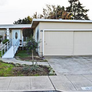 A suburban house with a garage and a ramp leading to the front door.