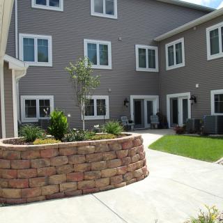 A well-maintained courtyard with garden beds and a multi-story building in the background.
